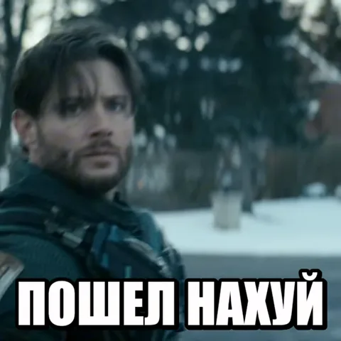 Бородатый мужчина в черном пальто на улице указывает пальцем вперед, сопровождая жест надписью с грубым отказом.