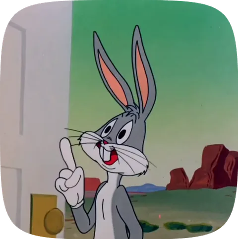 Серый кролик Багз Банни из мультфильма Looney Tunes указывает пальцем вверх, стоя на фоне пустыни.