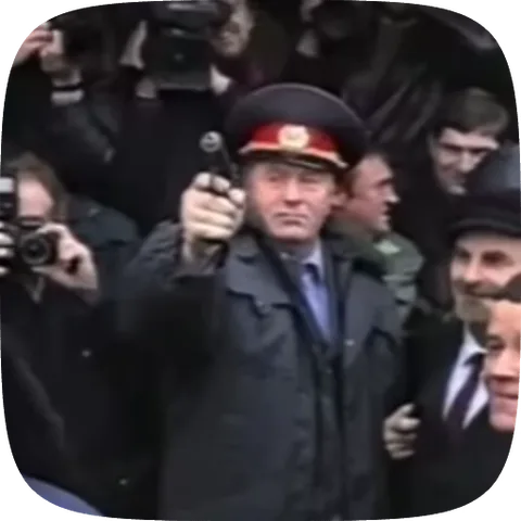 Анимация мужчины в полицейской форме, который держит пистолет перед собой, глядя прямо в объектив. На заднем плане видны другие люди.