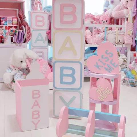 Розовые и голубые кубики с буквами складываются в слово BABY. Рядом стоит детская бутылочка.