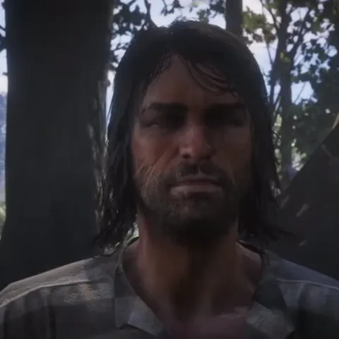 Крупный план лица ковбоя из видеоигры Red Dead Redemption 2. Он хмурится и смотрит прямо в камеру с серьезным выражением.