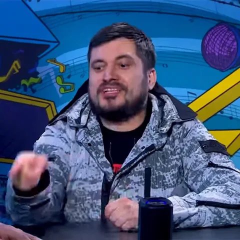 Мужчина смеется и кивает головой, показывая одобрение.