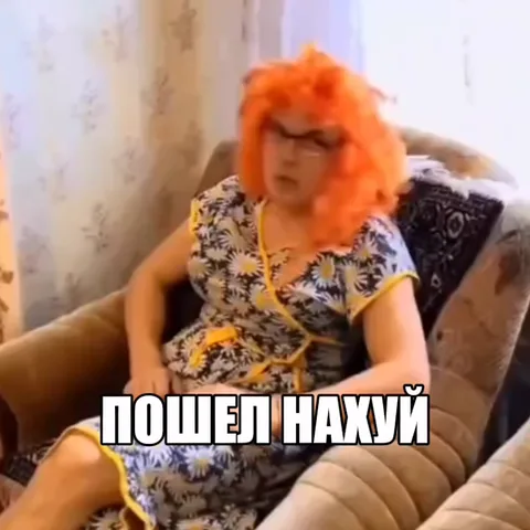 Женщина в рыжем парике на диване с надписью «ПОШЕЛ НАХУЙ».