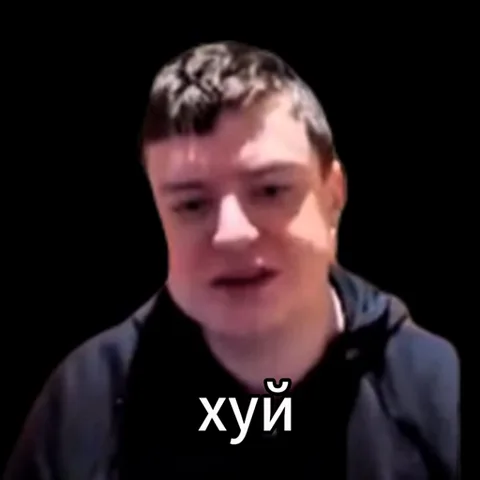Мужчина в темной одежде на черном фоне произносит фразу с ненормативной лексикой, текст отображается внизу.