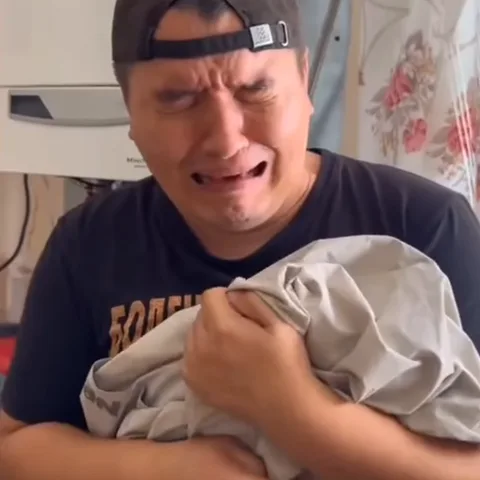 Плачущий мужчина обнимает ткань