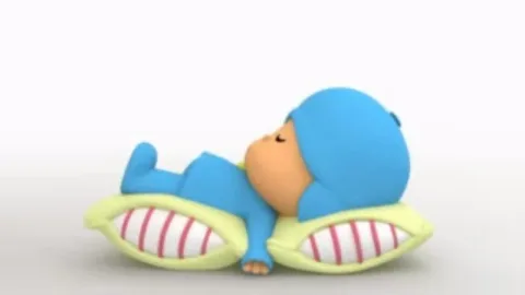 3D-персонаж Pocoyo лежит на животе на белой подушке с красными полосками и спит.