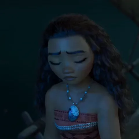 Анимация персонажа Моаны из мультфильма Disney, которая держит в руках светящийся зеленый камень и смотрит на него с грустью или удивлением.