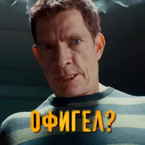 Мужчина в полосатой тюремной робе смотрит в камеру, затем крупным планом показывается его сжатый кулак, после чего он атакует человека в красном костюме.