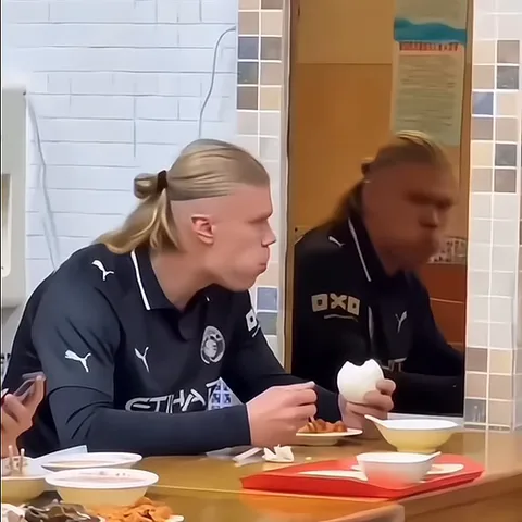 Спортсмен в черной форме ест вареное яйцо перед зеркалом.