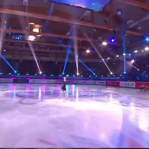 Фигуристка на ледовой арене показывает руками сердце