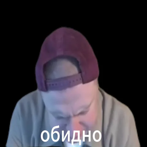 Грустный мужчина в кепке опускает голову на черном фоне с текстом «обидно».