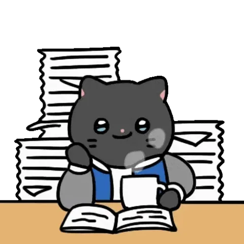 Милый серый кот в очках читает книгу за столом с бумагами и пьет чай.