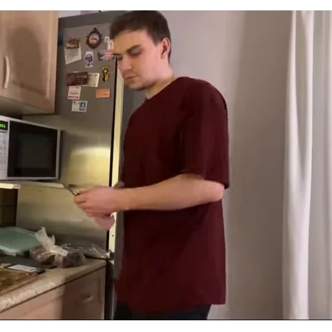 Анимация парня в бордовой футболке, который точит нож на кухне.