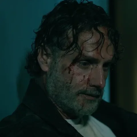 Мужчина с бородой и кровью на лице закрывает глаза и запрокидывает голову назад.