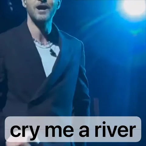 Певец на сцене под синими прожекторами, снизу текстовая плашка «cry me a river».