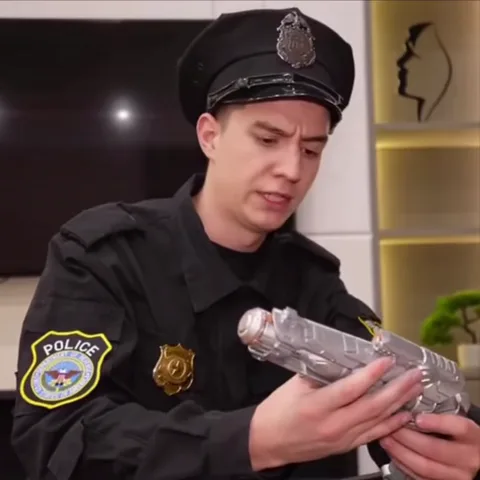 Анимация человека в полицейской форме, который держит в руках прозрачный пистолет и смотрит на него с удивлением.