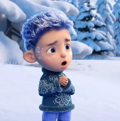 3D-персонаж мальчика с синей шевелюрой и узором из снежинок на лице, одетый в зимнюю одежду, складывает руки в мольбе на фоне снега и елей.
