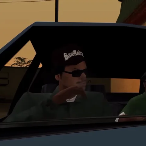 Мужчина в зелёной куртке и бейсболке San Andreas курит, находясь внутри машины. На заднем плане видно оранжевое небо заката.