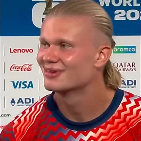 Эрлинг Холанд улыбается во время интервью на фоне спонсорских баннеров FIFA World Cup 2026.