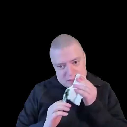 Мужчина с бритой головой ест, вытирает лицо салфеткой и смотрит вниз. На видео есть субтитры.