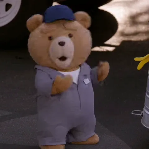 Анимация с персонажем Ted из фильма «Тед», одетым как механик или рабочий. Он жестикулирует лапами и меняет выражение морды на удивленное.