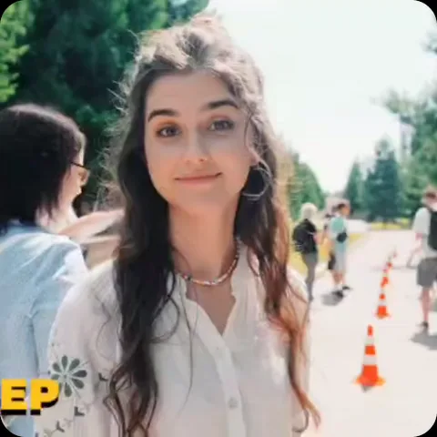 Улыбающаяся девушка на улице делает жест рукой «окей», демонстрируя одобрение или согласие.