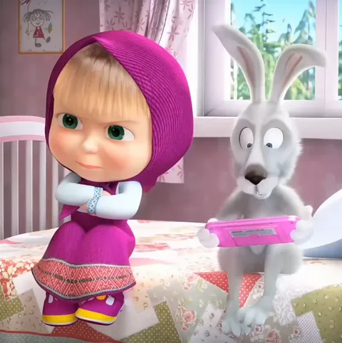 3D-анимация: Маша из мультфильма «Маша и Медведь» сидит на кровати со скрещенными руками и обиженным лицом, пока серый Заяц рядом играет в портативную игровую приставку.