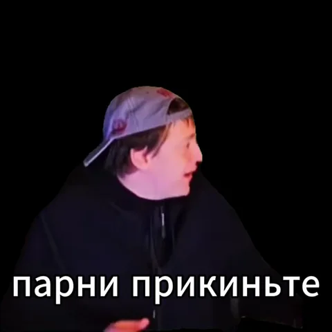 Молодой человек в черной толстовке и серой кепке поворачивает голову и активно жестикулирует на черном фоне с текстом.